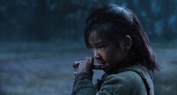 Movie still from “A Writer's Odyssey” (2021), directed by Yang Lu – A young girl is holding a pipe in her mouth; Close Up shot, Over the shoulder angle