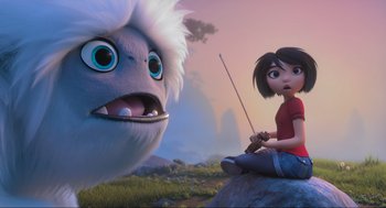 Movie still from “Abominable” (2019), directed by Todd Wilderman – A woman sitting on a rock next to an animal; Wide shot, Low angle