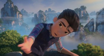 Movie still from “Abominable” (2019), directed by Todd Wilderman – A boy is laying on a ledge in a valley; Medium shot, Over the shoulder angle