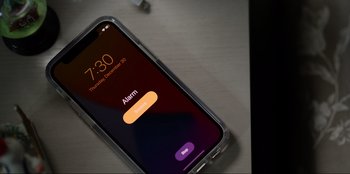 Movie still from “About Fate” (2022), directed by Marius Vaysberg – An alarm on the screen of an apple iphone; Extreme Close Up shot, High angle