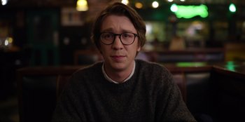 Movie still from “About Fate” (2022), directed by Marius Vaysberg – A man with glasses is sitting in front of the camera; Close Up shot, Over the shoulder angle