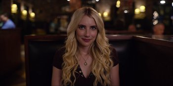 A woman with long blonde hair sitting at a table