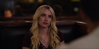 Movie still from “About Fate” (2022), directed by Marius Vaysberg – A woman with long blonde hair sitting in front of a bar; Close Up shot, Over the shoulder angle