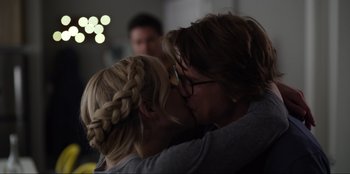 Movie still from “About Fate” (2022), directed by Marius Vaysberg – Two women kissing each other in front of a blurry background; Close Up shot, Over the shoulder angle