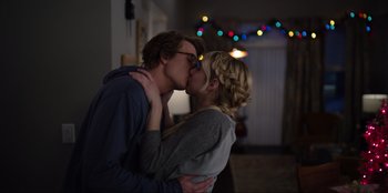 Movie still from “About Fate” (2022), directed by Marius Vaysberg – A man and a woman kissing each other in front of lights; Close Up shot, Low angle