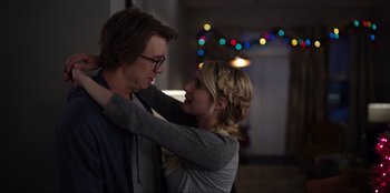 Movie still from “About Fate” (2022), directed by Marius Vaysberg – A man and a woman embracing each other in front of lights; Close Up shot, Over the shoulder angle