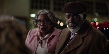 Movie still from “About Fate” (2022), directed by Marius Vaysberg – An older man and woman standing next to each other; Close Up shot, Over the shoulder angle