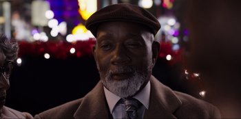 Movie still from “About Fate” (2022), directed by Marius Vaysberg – An older man wearing a hat and a tie; Close Up shot, Low angle