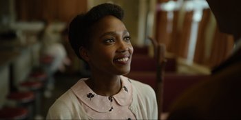 Movie still from “About Fate” (2022), directed by Marius Vaysberg – A person smiling at the camera; Close Up shot, Over the shoulder angle