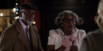 Movie still from “About Fate” (2022), directed by Marius Vaysberg – An older man standing next to an older woman; Medium shot, Over the shoulder angle