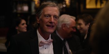 Movie still from “About Fate” (2022), directed by Marius Vaysberg – A person wearing a suit and a bow tie; Close Up shot, Over the shoulder angle