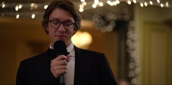 Movie still from “About Fate” (2022), directed by Marius Vaysberg – A man holding a microphone in his hand; Close Up shot, Over the shoulder angle