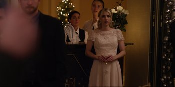 Movie still from “About Fate” (2022), directed by Marius Vaysberg – A woman in a white dress standing in front of two men; Medium shot, Over the shoulder angle