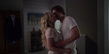 Movie still from “About Fate” (2022), directed by Marius Vaysberg – A man and a woman are hugging in a room; Medium shot, Over the shoulder angle