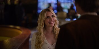 Movie still from “About Fate” (2022), directed by Marius Vaysberg – A woman with long blonde hair smiling at someone in the background; Close Up shot, Over the shoulder angle