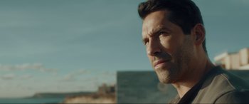 Movie still from “Accident Man: Hitman's Holiday” (2022), directed by George Kirby – A man's face in the desert; Close Up shot, Over the shoulder angle