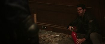 Movie still from “Accident Man: Hitman's Holiday” (2022), directed by George Kirby – A person holding a fire extinguisher on the ground; Medium shot, High angle