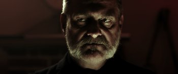 Movie still from “Accident Man: Hitman's Holiday” (2022), directed by George Kirby – A person with a beard; Close Up shot, Low angle
