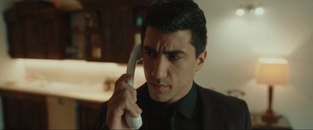 Movie still from “Accident Man: Hitman's Holiday” (2022), directed by George Kirby – A person talking on a phone; Close Up shot, Low angle