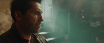 Movie still from “Accident Man: Hitman's Holiday” (2022), directed by George Kirby – A man's face in front of stairs; Close Up shot, Over the shoulder angle