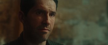 Movie still from “Accident Man: Hitman's Holiday” (2022), directed by George Kirby – A man's face with a brick wall in the background; Close Up shot, Over the shoulder angle