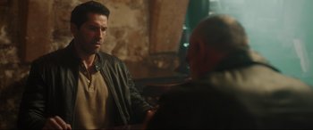 Movie still from “Accident Man: Hitman's Holiday” (2022), directed by George Kirby – A man in a leather jacket talking to another man in a leather jacket; Medium shot, Over the shoulder angle