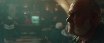 Movie still from “Accident Man: Hitman's Holiday” (2022), directed by George Kirby – A person with a beard; Close Up shot, Over the shoulder angle