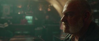 Movie still from “Accident Man: Hitman's Holiday” (2022), directed by George Kirby – A person with a beard; Close Up shot, Over the shoulder angle