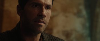 Movie still from “Accident Man: Hitman's Holiday” (2022), directed by George Kirby – A man's face in front of a brick wall; Close Up shot, Over the shoulder angle