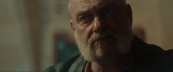 Movie still from “Accident Man: Hitman's Holiday” (2022), directed by George Kirby – An old man with a beard and a mustache; Close Up shot, Low angle