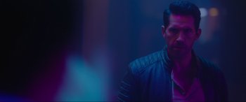 Movie still from “Accident Man: Hitman's Holiday” (2022), directed by George Kirby – A man wearing a leather jacket standing next to a wall; Close Up shot, Over the shoulder angle