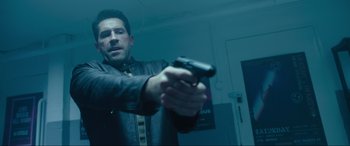 Movie still from “Accident Man: Hitman's Holiday” (2022), directed by George Kirby – A man holding a gun in a room; Medium shot, High angle