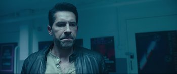 Movie still from “Accident Man: Hitman's Holiday” (2022), directed by George Kirby – A person wearing a leather jacket; Close Up shot, Over the shoulder angle