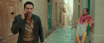 Movie still from “Accident Man: Hitman's Holiday” (2022), directed by George Kirby – A man standing in the middle of an alleyway; Medium shot, Over the shoulder angle