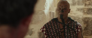 Movie still from “Accident Man: Hitman's Holiday” (2022), directed by George Kirby – A man with a face paint on his face; Close Up shot, Over the shoulder angle