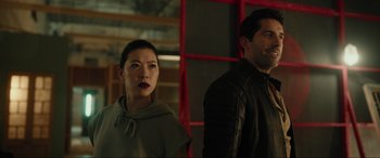 Movie still from “Accident Man: Hitman's Holiday” (2022), directed by George Kirby – A woman standing next to a man wearing a black jacket; Medium shot, Over the shoulder angle