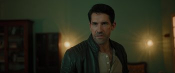 Movie still from “Accident Man: Hitman's Holiday” (2022), directed by George Kirby – A person wearing a leather jacket; Close Up shot, Over the shoulder angle