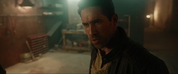 Movie still from “Accident Man: Hitman's Holiday” (2022), directed by George Kirby – A person wearing a jacket; Close Up shot, Over the shoulder angle