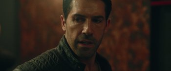 Movie still from “Accident Man: Hitman's Holiday” (2022), directed by George Kirby – A person wearing a jacket; Close Up shot, Over the shoulder angle