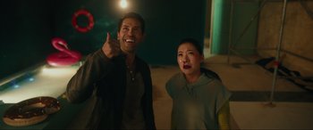 Movie still from “Accident Man: Hitman's Holiday” (2022), directed by George Kirby – A man and a woman standing next to each other; Medium shot, Over the shoulder angle