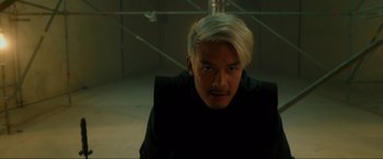 Movie still from “Accident Man: Hitman's Holiday” (2022), directed by George Kirby – A man with blonde hair is posing for a picture; Close Up shot, Low angle