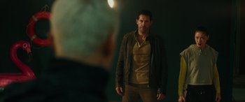 Movie still from “Accident Man: Hitman's Holiday” (2022), directed by George Kirby – A man standing in front of a wall; Medium shot, Over the shoulder angle