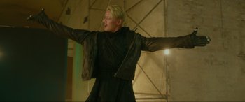 Movie still from “Accident Man: Hitman's Holiday” (2022), directed by George Kirby – A man with blond hair and a black jacket; Medium shot, Low angle