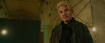Movie still from “Accident Man: Hitman's Holiday” (2022), directed by George Kirby – A man with blonde hair is posing for a picture; Close Up shot, Low angle