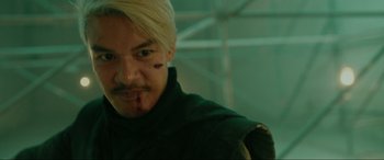 Movie still from “Accident Man: Hitman's Holiday” (2022), directed by George Kirby – A person with a scar on his face; Close Up shot, Over the shoulder angle