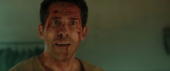 Movie still from “Accident Man: Hitman's Holiday” (2022), directed by George Kirby – A person with blood all over his face; Close Up shot, Over the shoulder angle