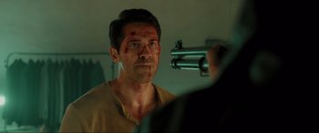 Movie still from “Accident Man: Hitman's Holiday” (2022), directed by George Kirby – A man is looking into a mirror with blood on his face; Close Up shot, Over the shoulder angle