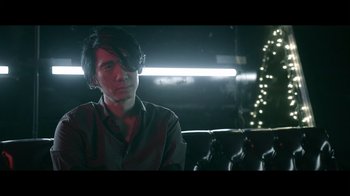 Movie still from “Adverse” (2020), directed by Brian A. Metcalf – A man sitting on a couch in a dark room; Close Up shot, Over the shoulder angle