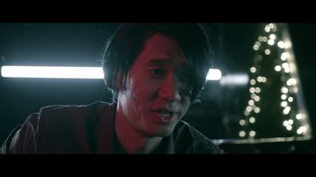 Movie still from “Adverse” (2020), directed by Brian A. Metcalf – A man with long black hair is looking at the camera; Close Up shot, Over the shoulder angle