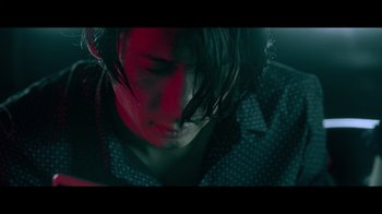 Movie still from “Adverse” (2020), directed by Brian A. Metcalf – A person with headphones on looking down at their face; Close Up shot, Low angle